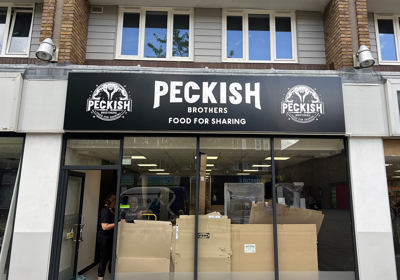 Peckish fascia sign with gloss black panel and white acrylic logo